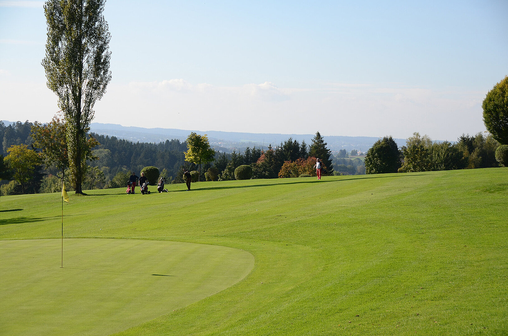 Golfplatz mit weitem Blick über eine Stadt im Tal